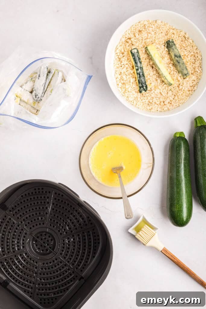 Crispy Air Fryer Zucchini Fries 14 Zucchini sticks being coated in seasoned breadcrumbs.
