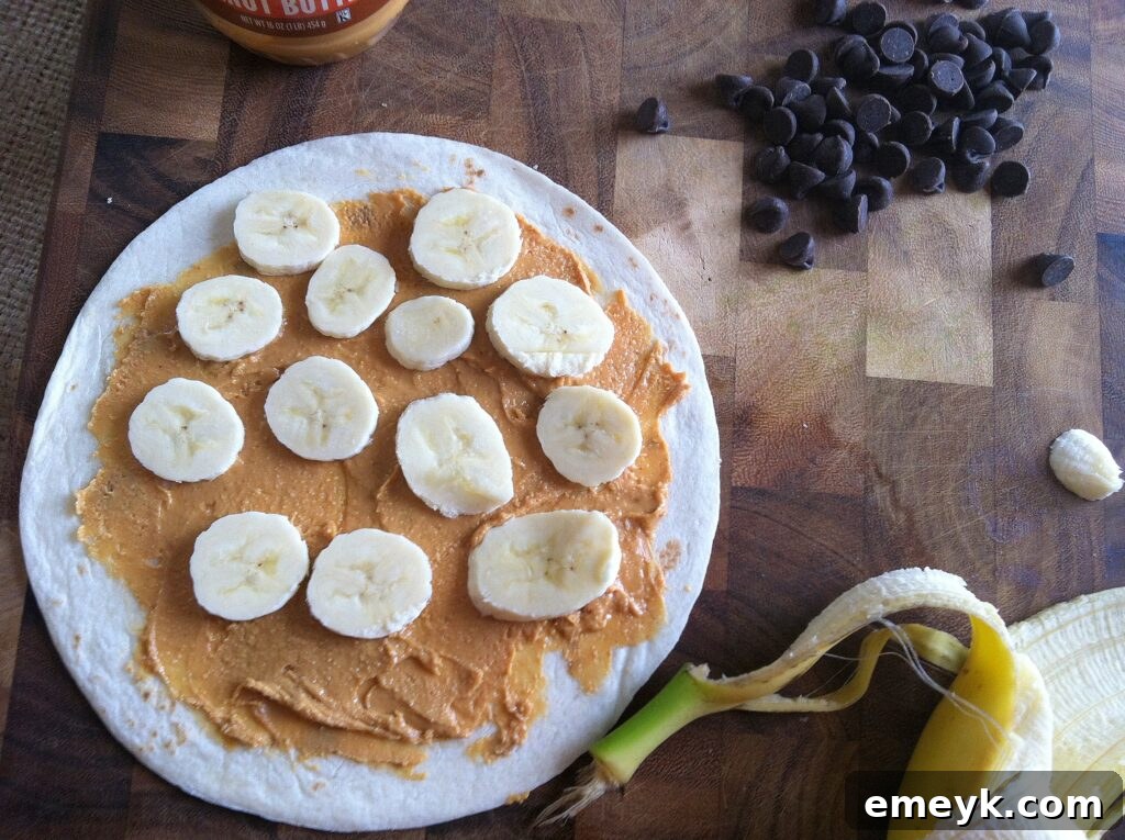 Bright red sliced strawberries carefully placed over the banana layer on a tortilla.