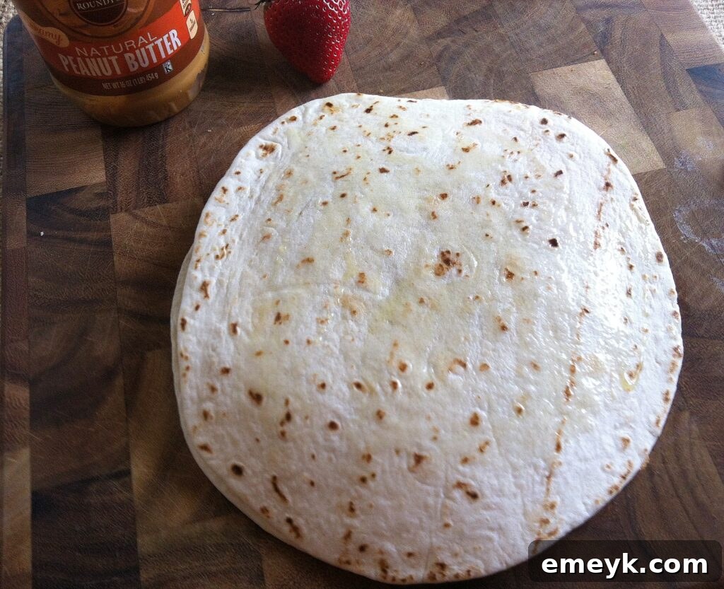 A beautifully assembled dessert quesadilla resting on a baking sheet, poised to go into the oven.