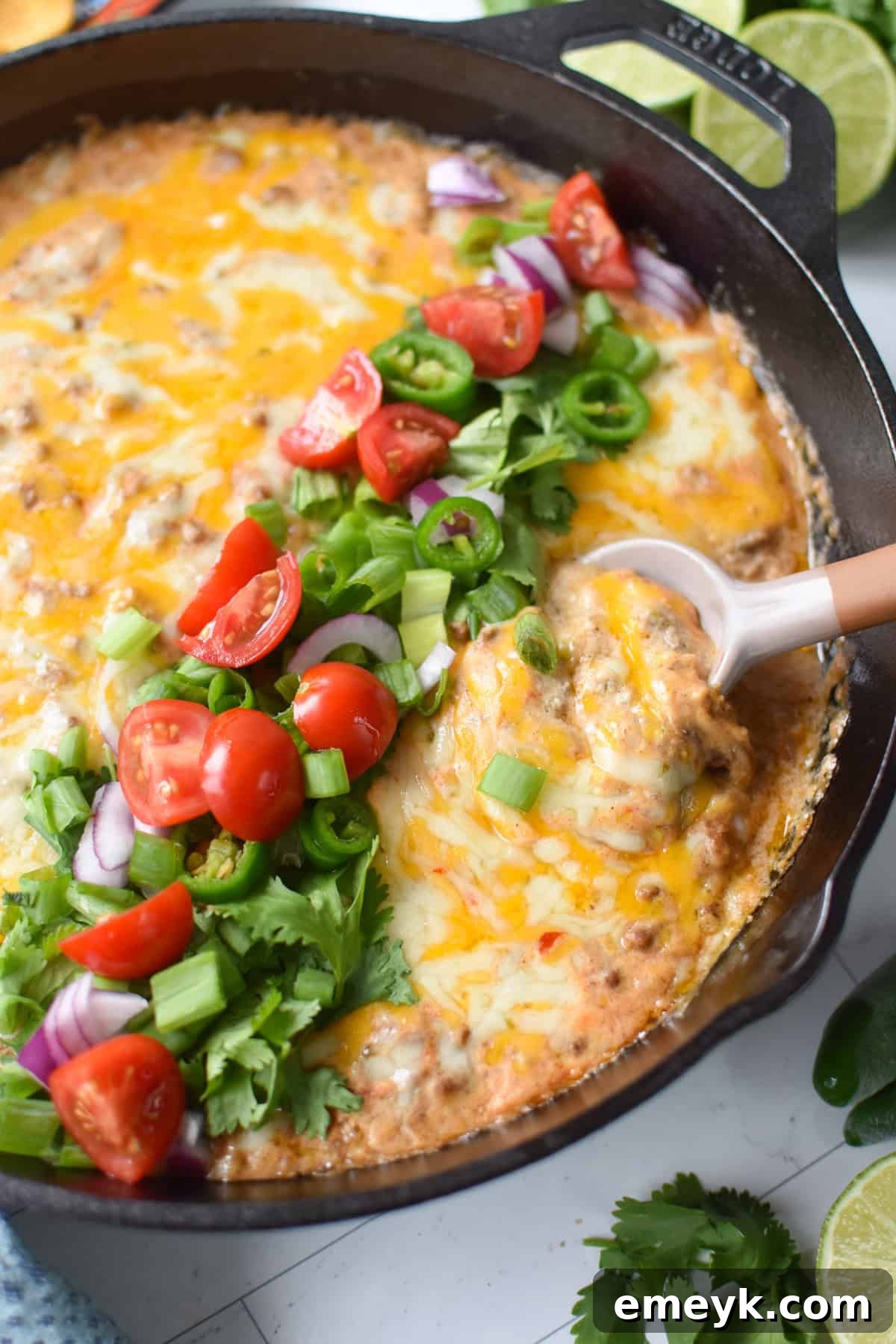 Beefed-Up Cottage Cheese Queso 2 Cottage cheese beef dip baked in a black cast iron skillet and garnished with diced tomatoes, green onion, cilantro and red onions.