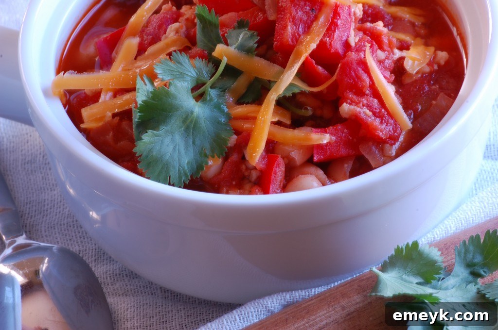 A large, steaming bowl of healthy Turkey and White Bean Chili garnished with fresh herbs and a dollop of sour cream, ready to be enjoyed.