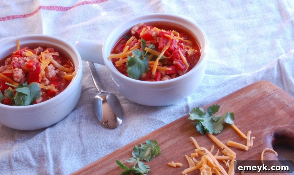 A bowl of hot Turkey and White Bean Chili served with a side of cornbread, highlighting its rustic and comforting appeal.