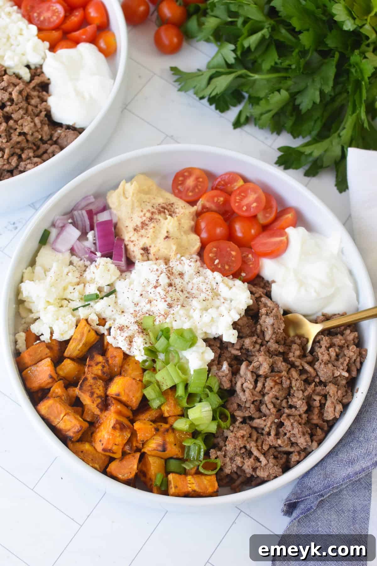 A completed Sweet Potato Cottage Cheese Bowl, featuring all components beautifully arranged and ready to eat, with a gold fork poised to dig in.