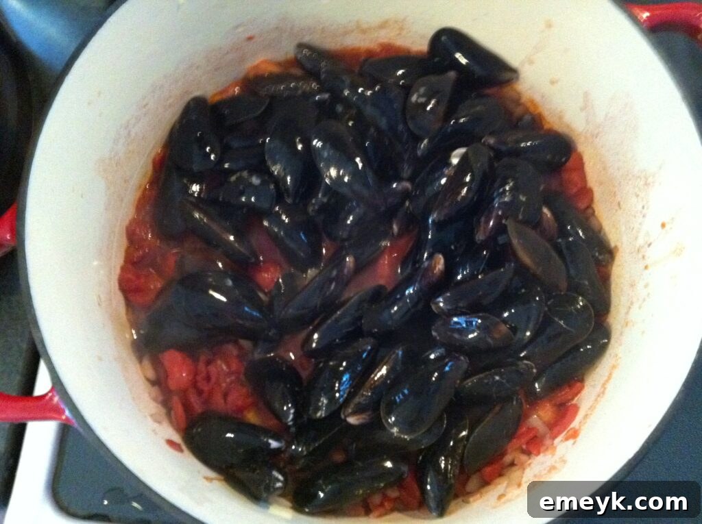 Mussels simmering in a delicious smoked Spanish paprika broth, covered with a lid
