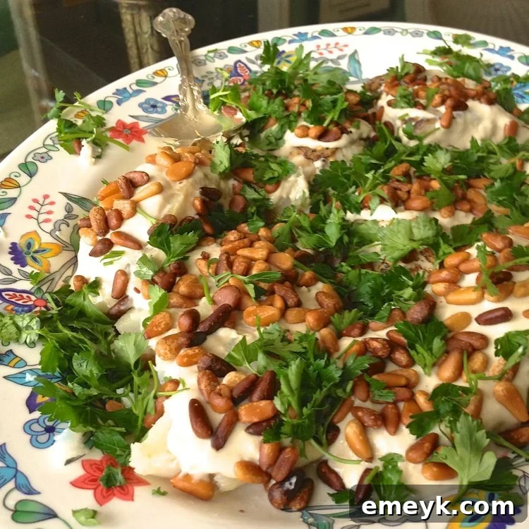 Easy Baked White Fish Recipe on a plate with a side of lemon wedges and a fork.