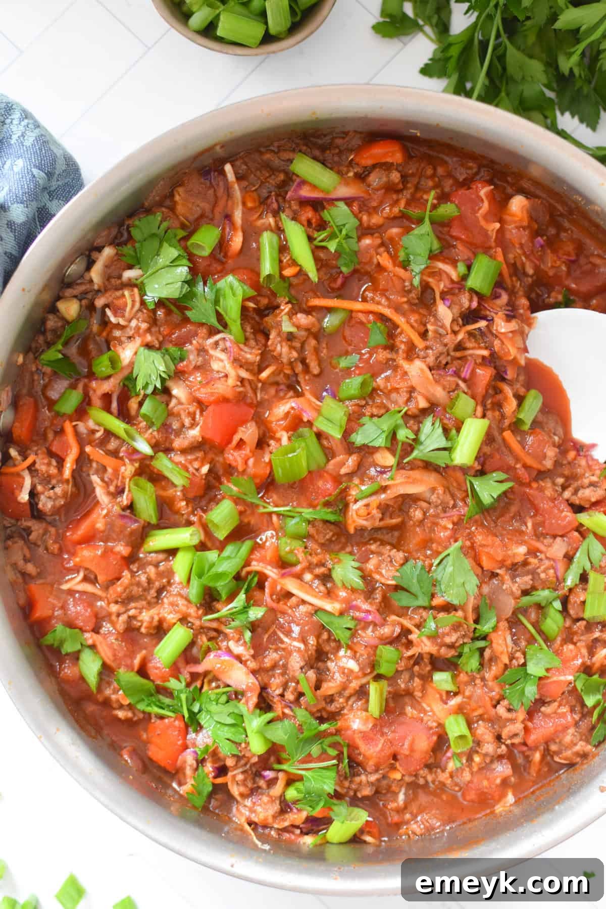 Zesty Mediterranean Beef and Cabbage Sauté 2 Mediterranean Beef and Cabbage Stir-fry in a skillet with a white spoon