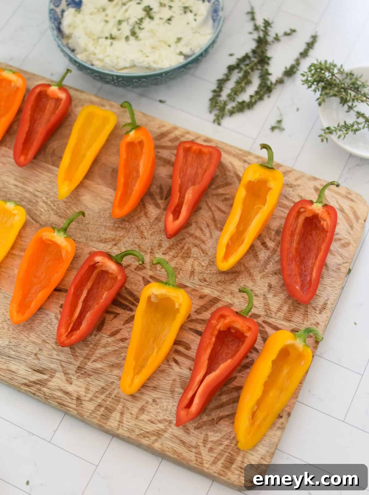 Creamy Goat Cheese-Filled Mini Peppers 9 Mini sweet peppers halves, cleaned and ready for stuffing, laid out on a baking sheet.