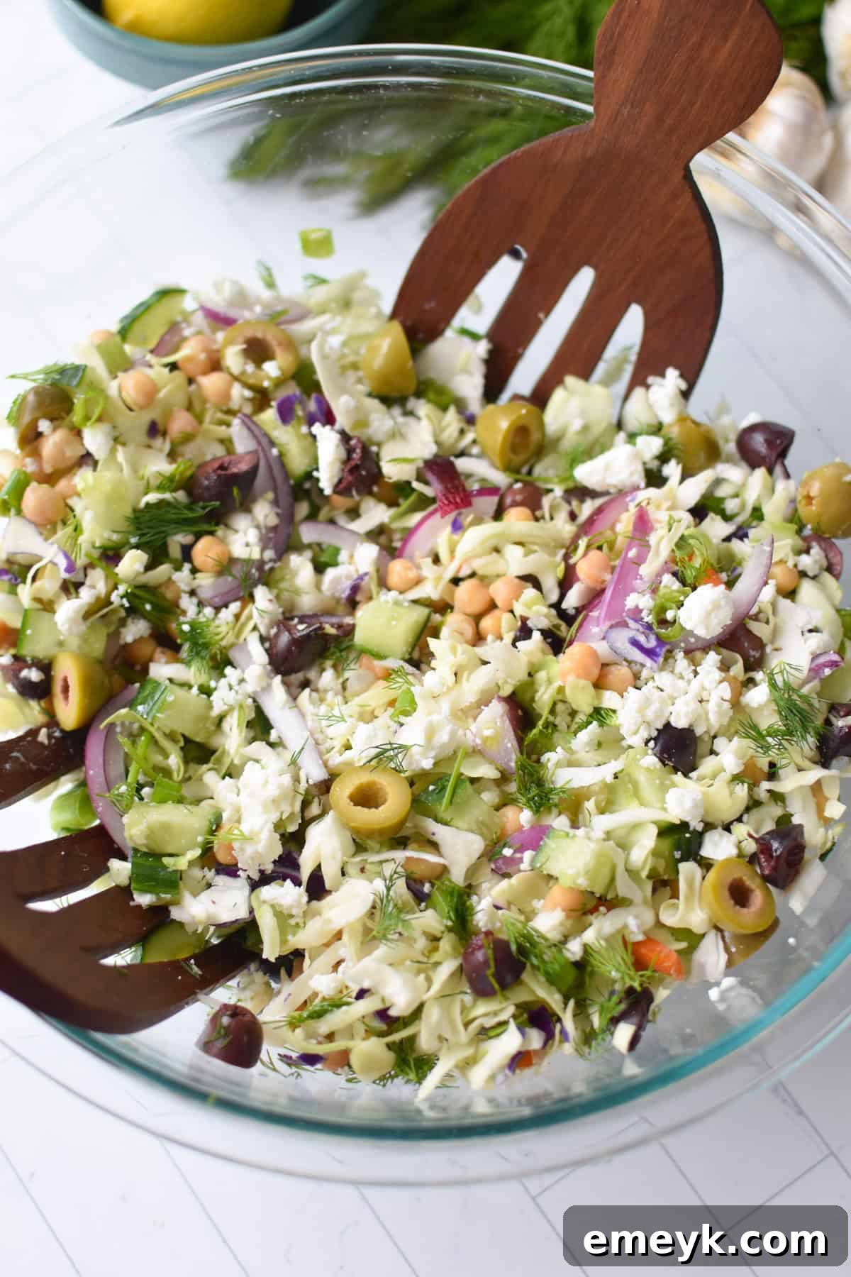 Large bowl of vibrant Greek Cabbage Salad (Lahanosalata) with a mix of shredded cabbage, chickpeas, and fresh vegetables.