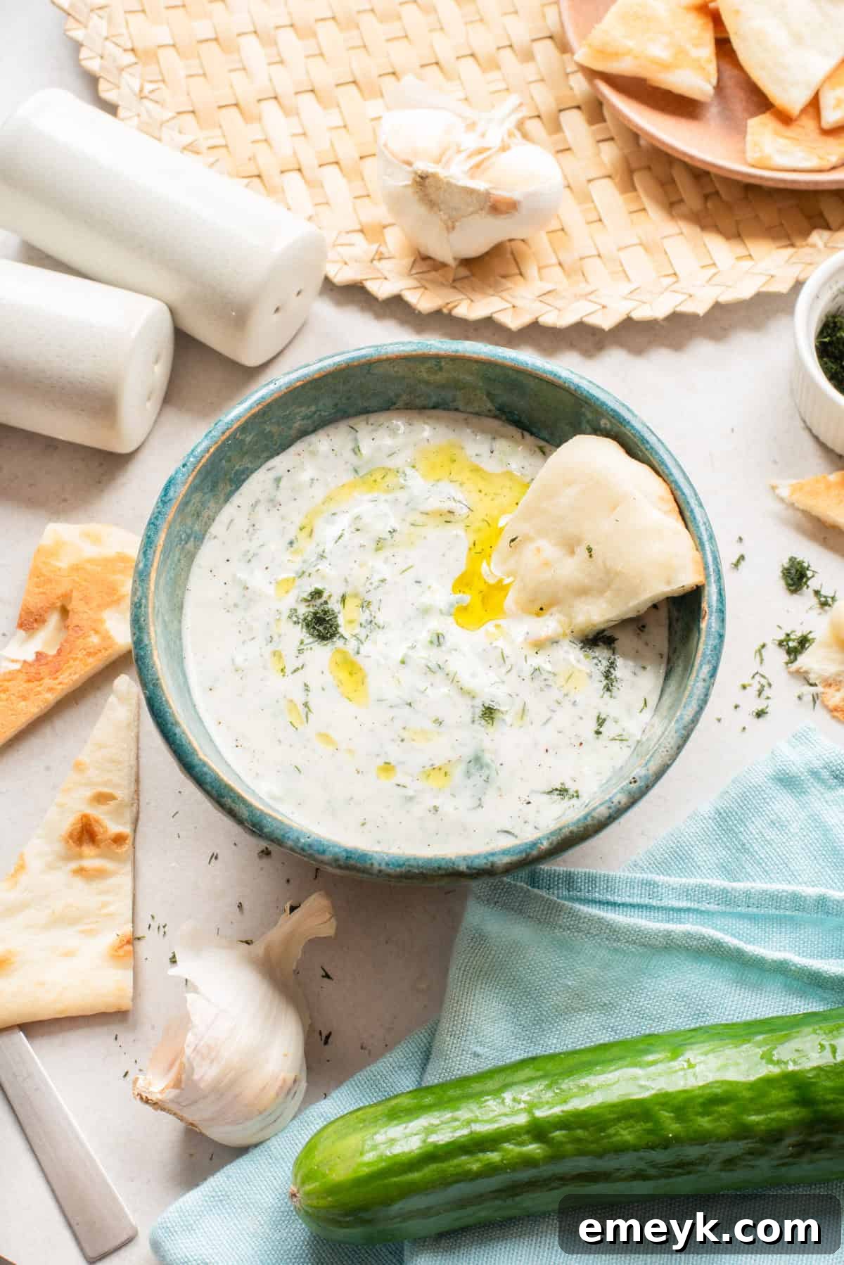 Traditional Greek Tzatziki sauce in a blue dish, garnished with fresh dill