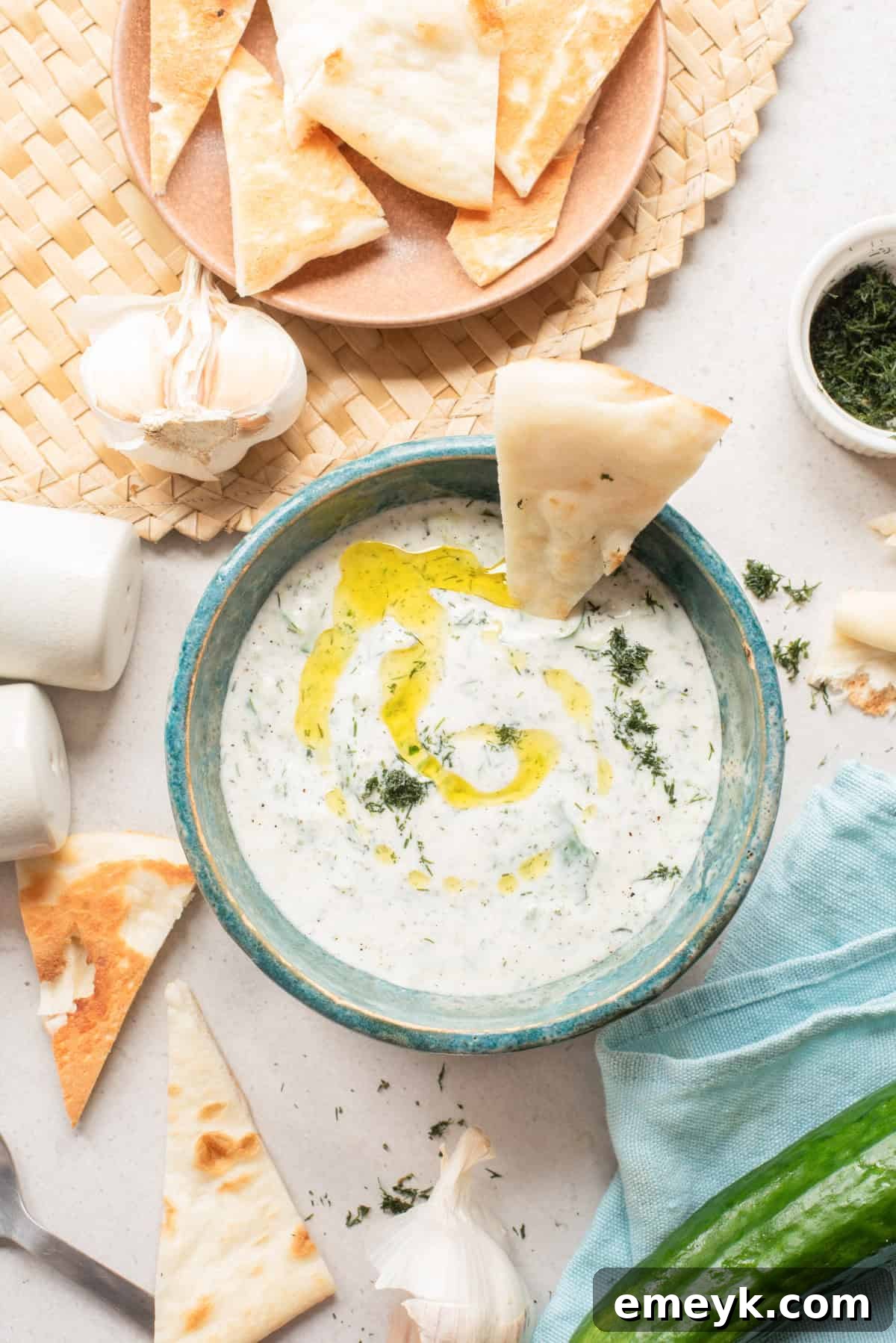 Cucumber Garlic Yogurt Sauce in a bowl with warm pita triangles