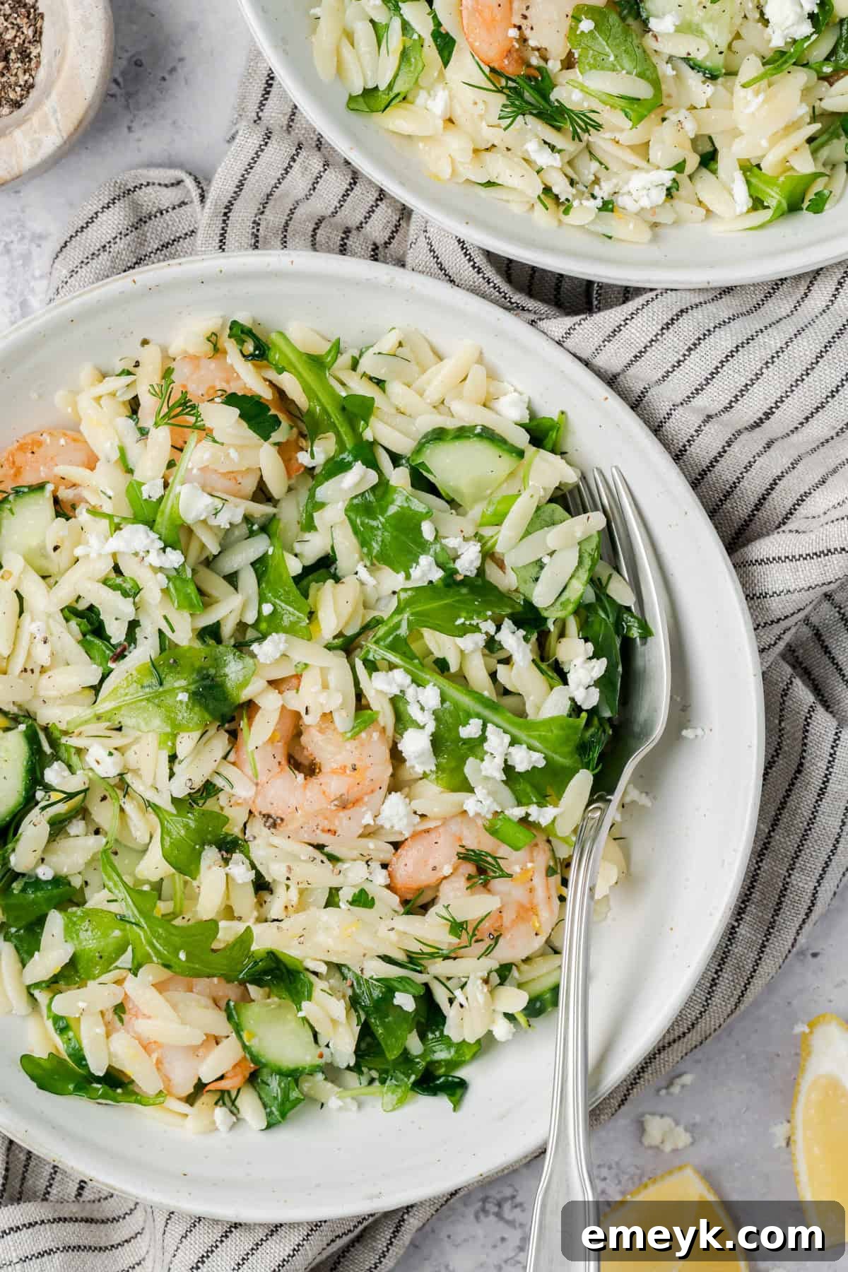 Lemony Shrimp Orzo Pasta Salad on a white plate with a fork