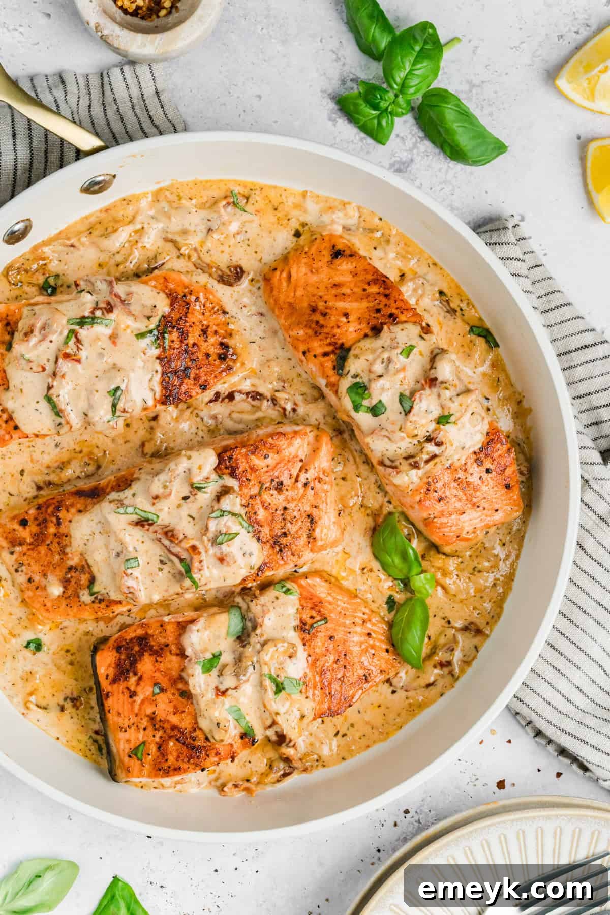 Creamy Tuscan Marry Me Salmon in a white skillet 