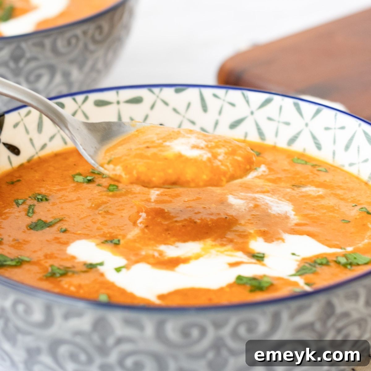 Rustic bowl of Lentil Tomato Soup with a spoon.