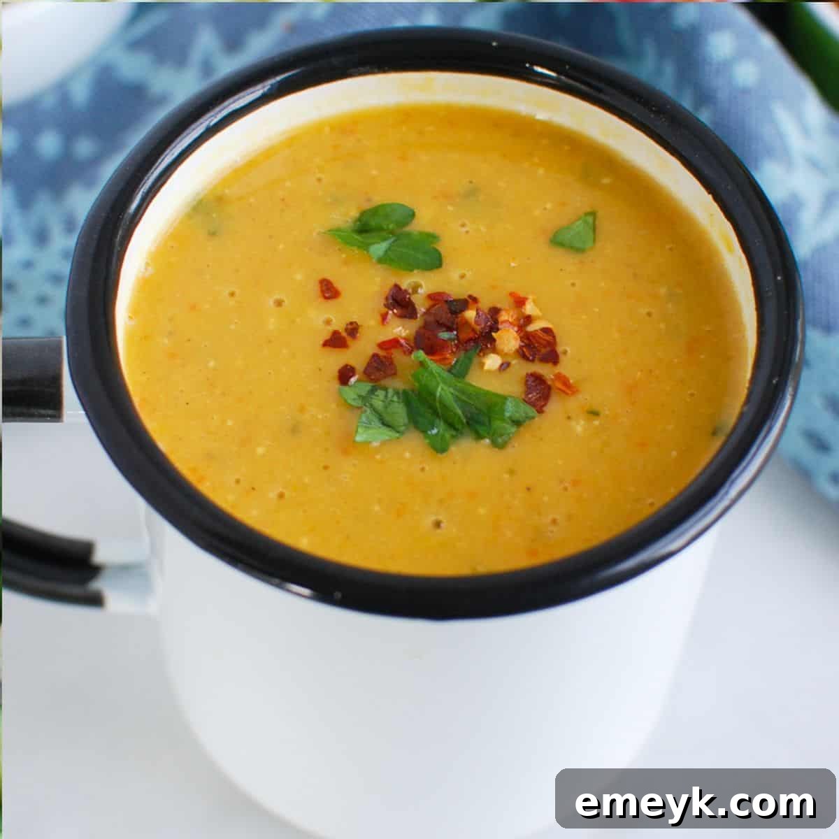 Lebanese Lentil Soup, garnished with fresh herbs in a white bowl.