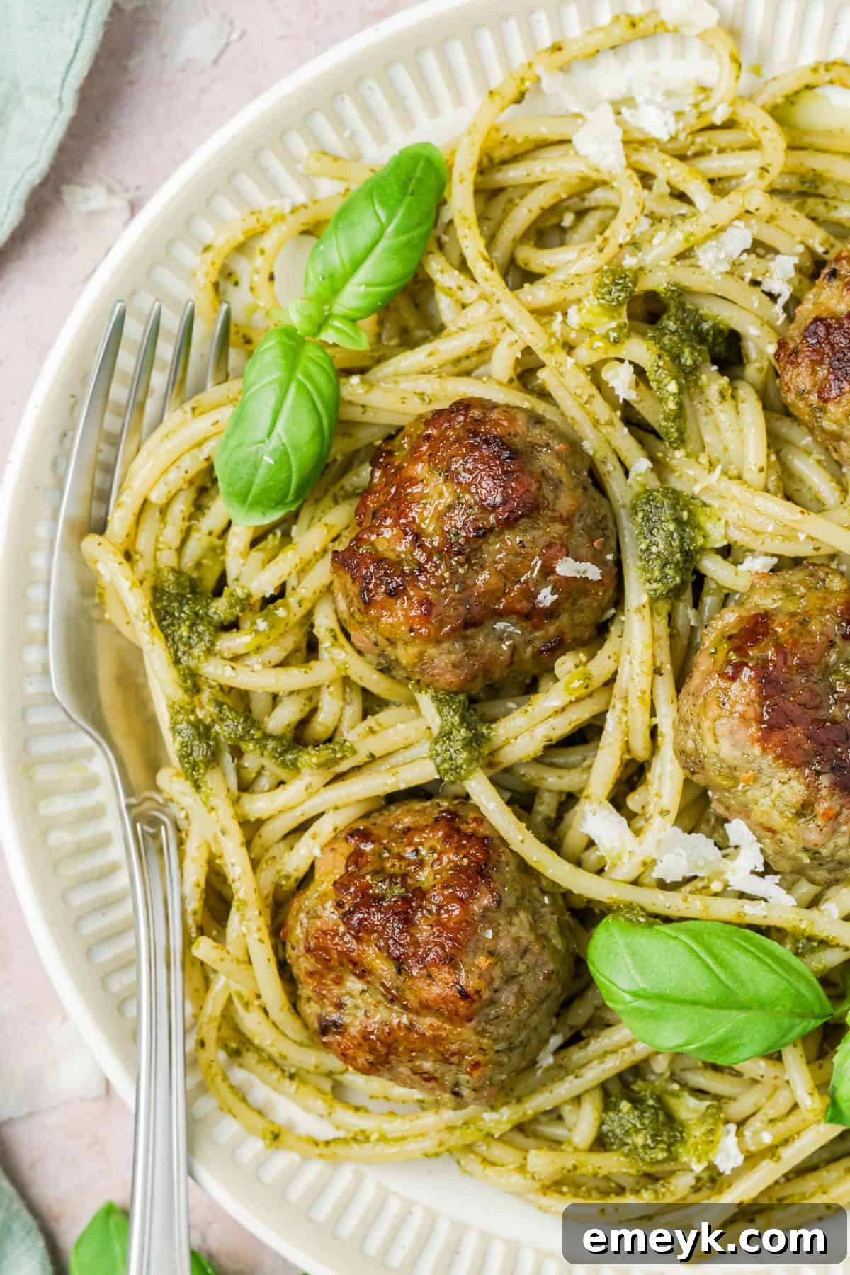 Turkey Pesto Meatballs on a white plate with fresh basil garnish