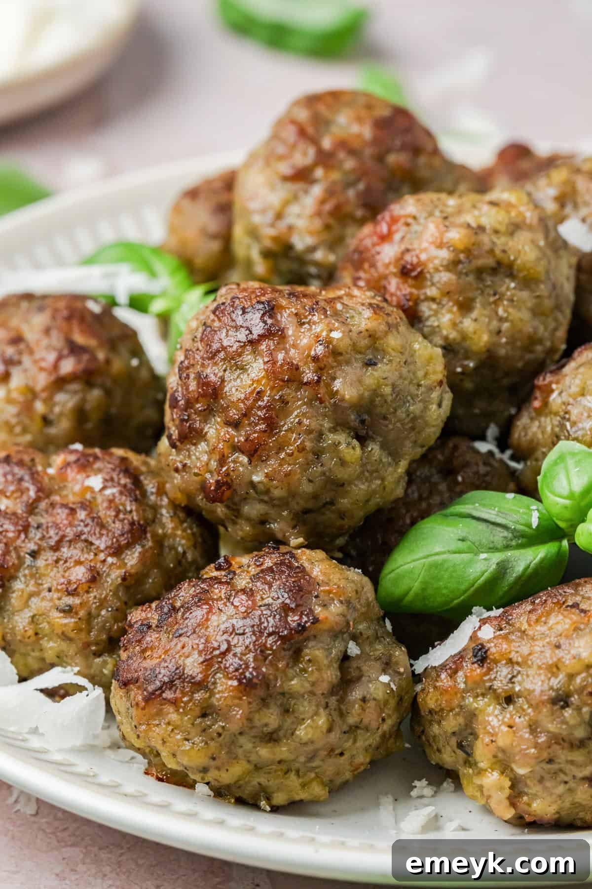 Pesto Turkey Meatballs with fresh basil garnish on a platter.