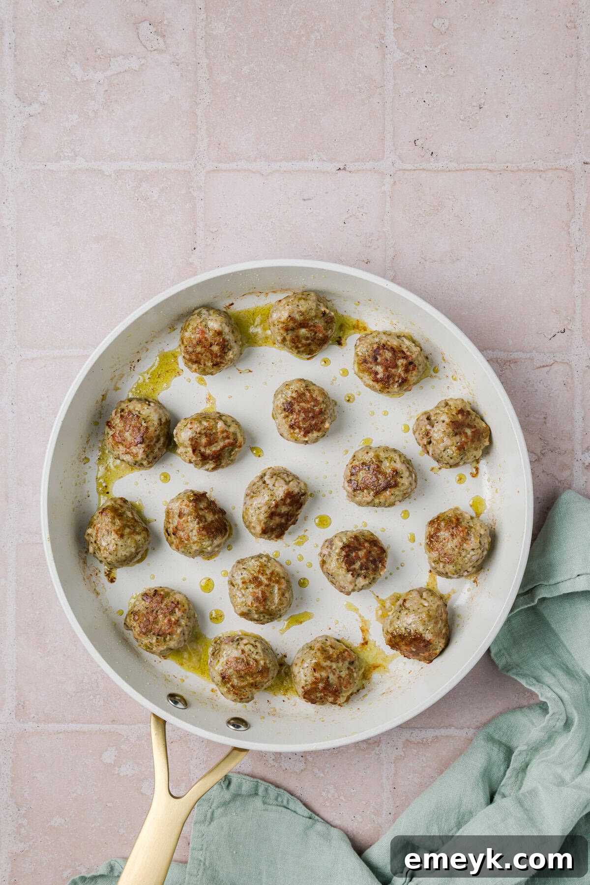 Pesto Turkey Meatballs browning in a skillet.