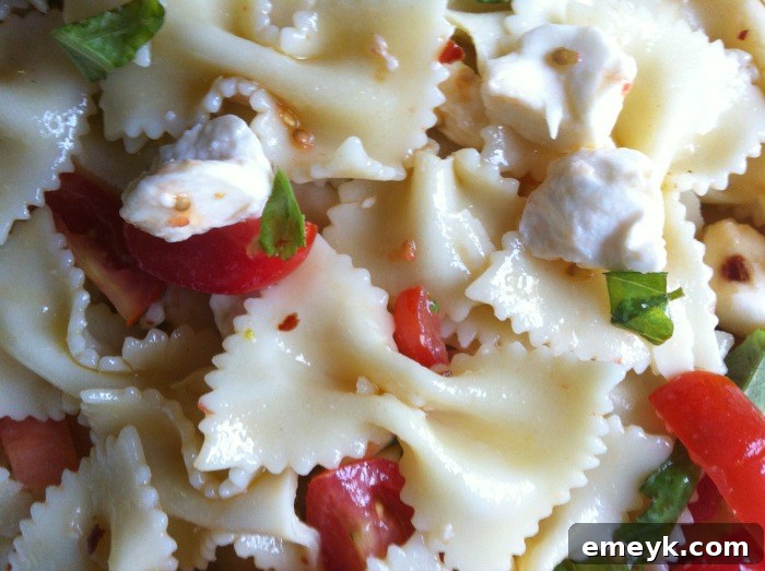 Vibrant Caprese Pasta 8 Close-up shot of Caprese Pasta Salad, highlighting the texture of the pasta, the freshness of basil, and the creamy mozzarella.