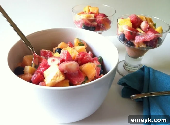 A close-up of the delicious Fruit Salad with Yogurt Honey Lemon Dressing, showing the vibrant colors and fresh mint garnish.