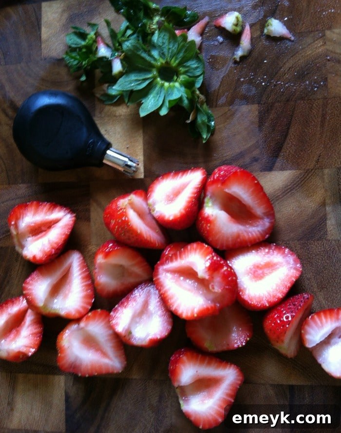 Perfectly sliced strawberries, showcasing the clean cuts after hulling, ready for a fruit salad.