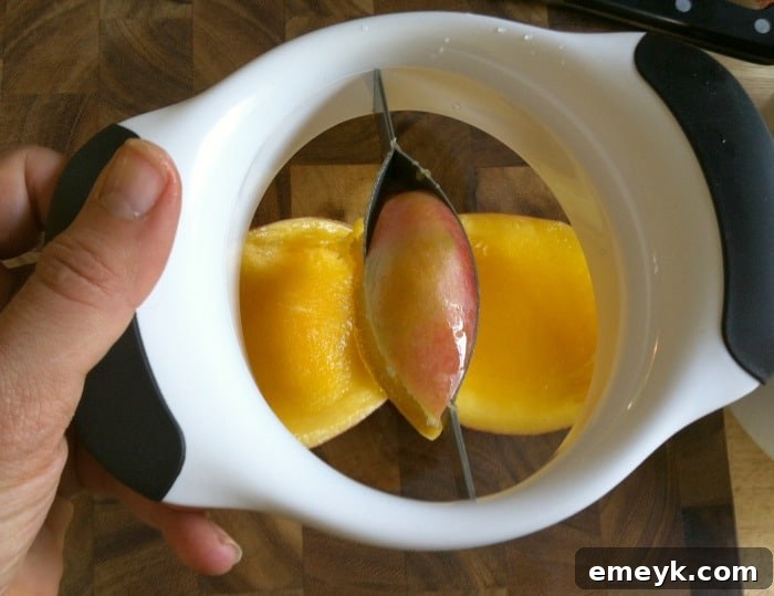 Close-up of a mango, showing the clean cut made by the splitter, leaving the juicy flesh ready to be enjoyed.