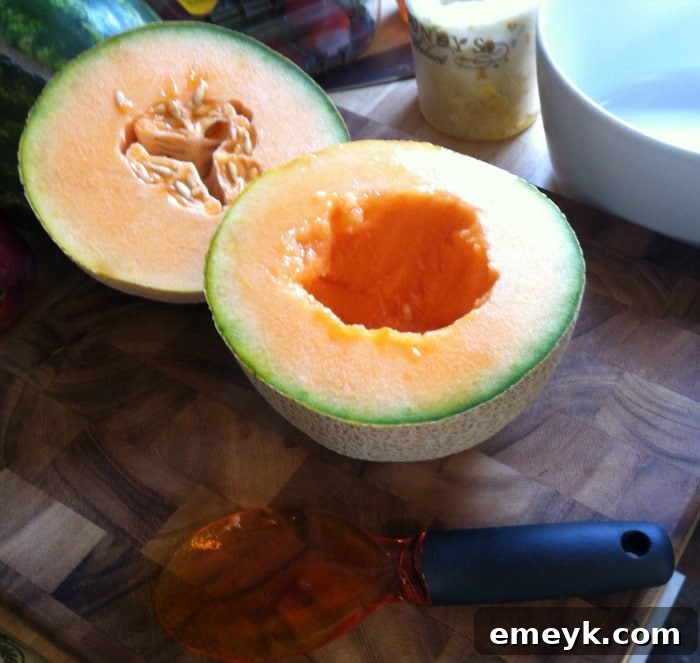 A close-up of the interior of a cantaloupe, showing the smooth, clean surface after seed removal using a fruit scoop.