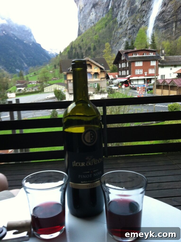 Woman enjoying a glass of wine on a patio with a stunning waterfall view in Interlaken, Switzerland