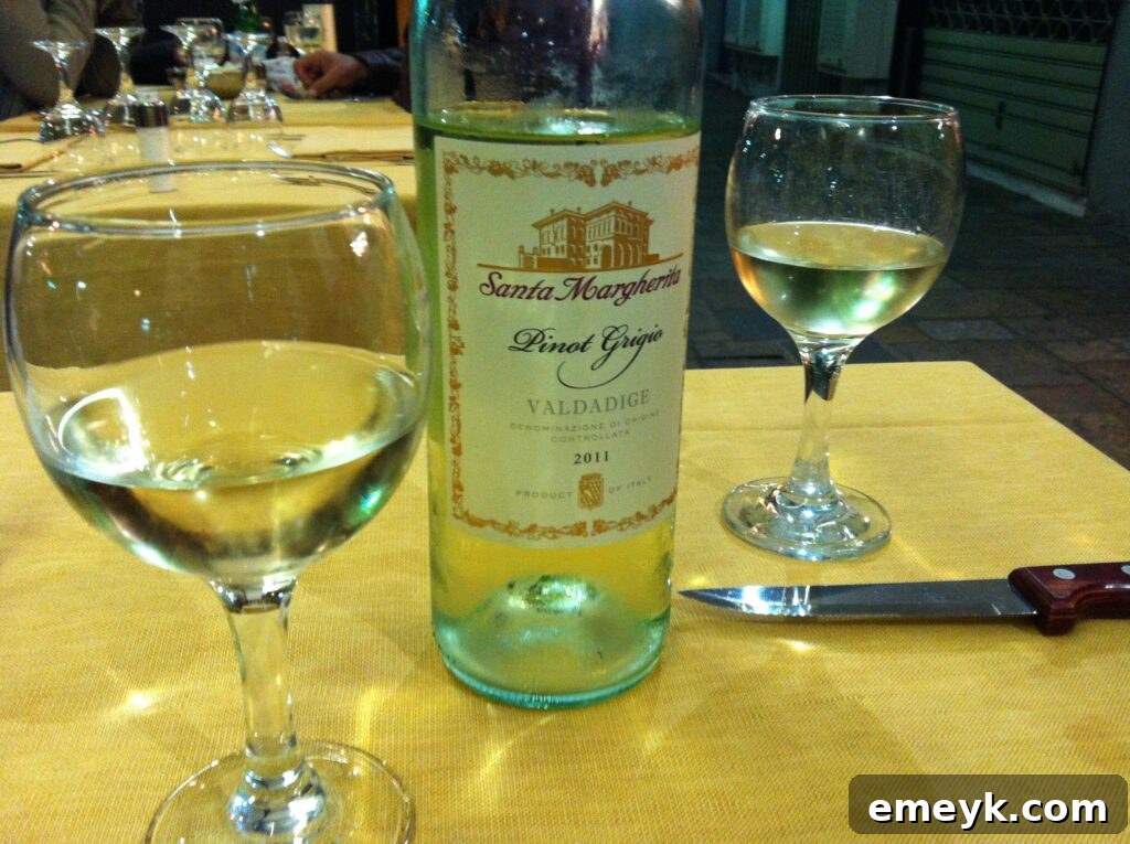 A glass of exquisite Italian white wine, possibly Santa Margherita Pinot Grigio, against a scenic backdrop