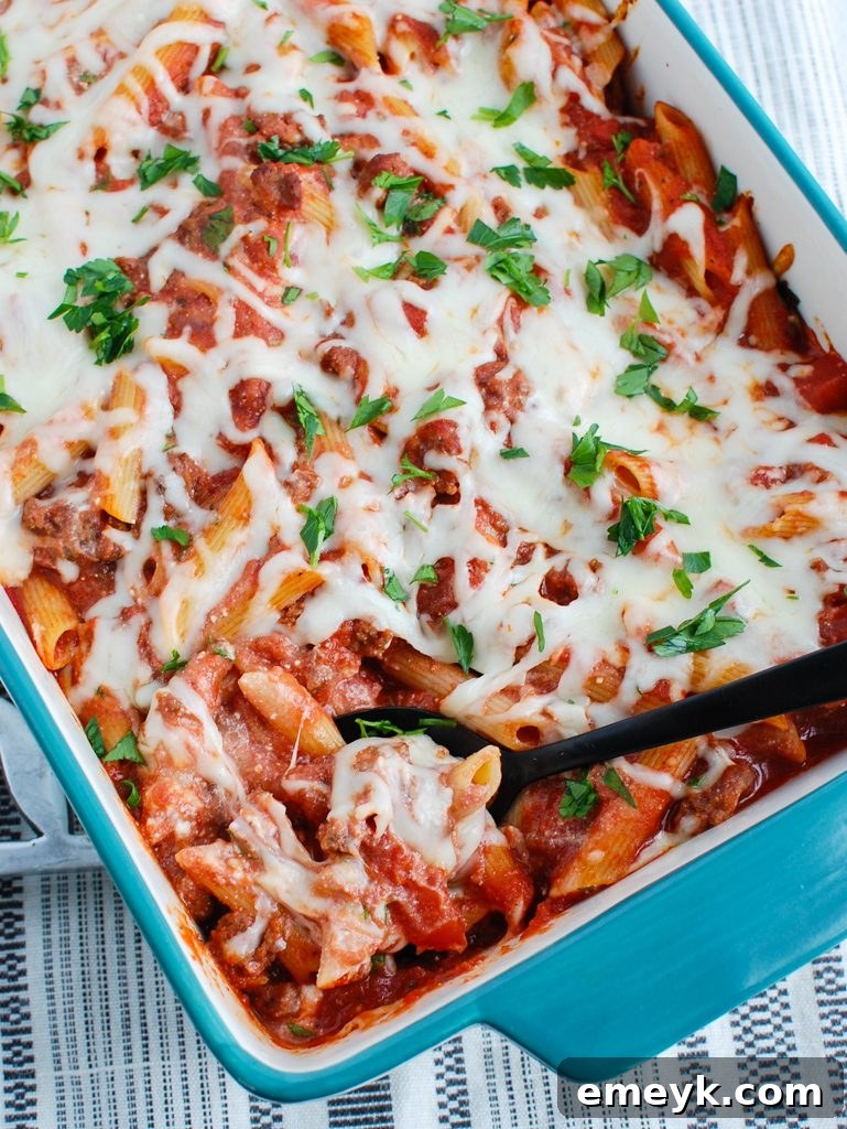 Baked Ziti with Ricotta being scooped with a large spoon