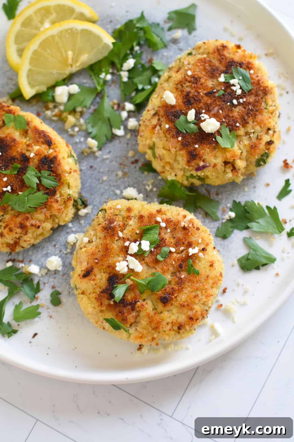 Mediterranean Salmon Cakes with Feta and Herbs, garnished with fresh parsley and lemon wedges