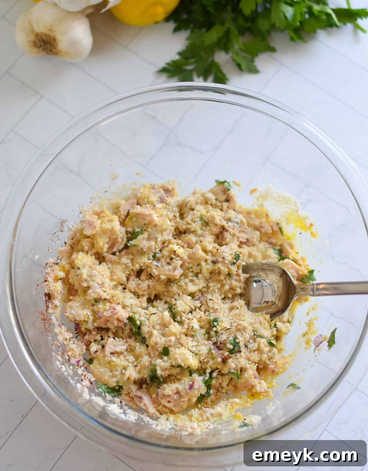 Salmon Patties recipe ingredients mixed in a clear bowl, a uniform mixture ready for forming