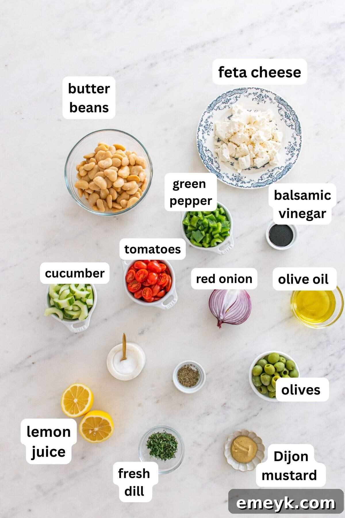 Individual ingredients for Greek Butter Bean Salad laid out on a table.
