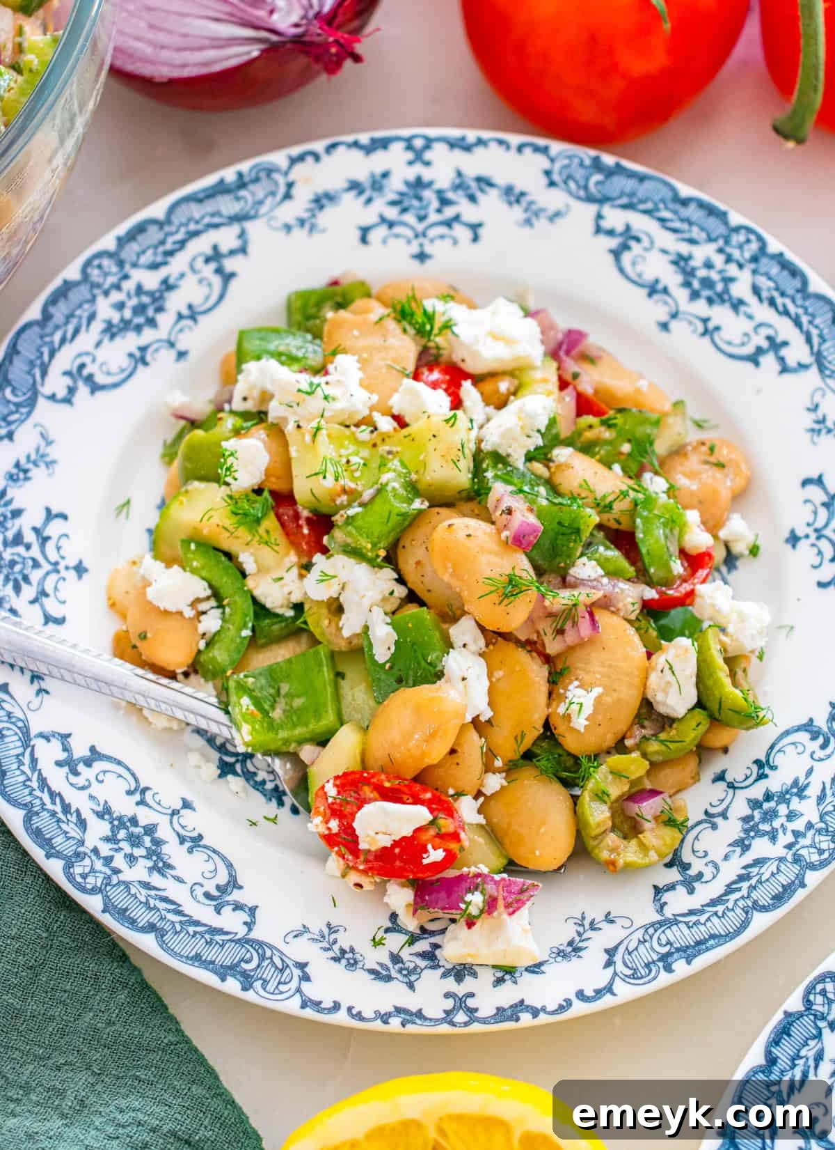 Close-up of Greek Butter Bean Salad with lemon wedges and fresh dill.