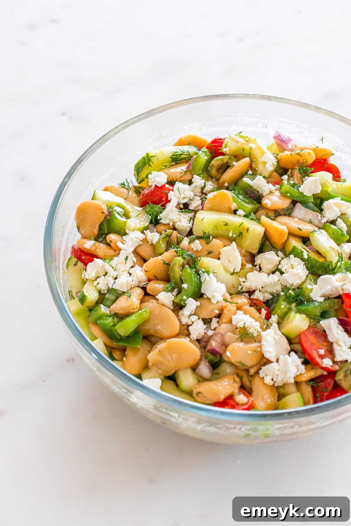 Finished Greek Butter Bean Salad in a glass serving bowl, topped with feta.