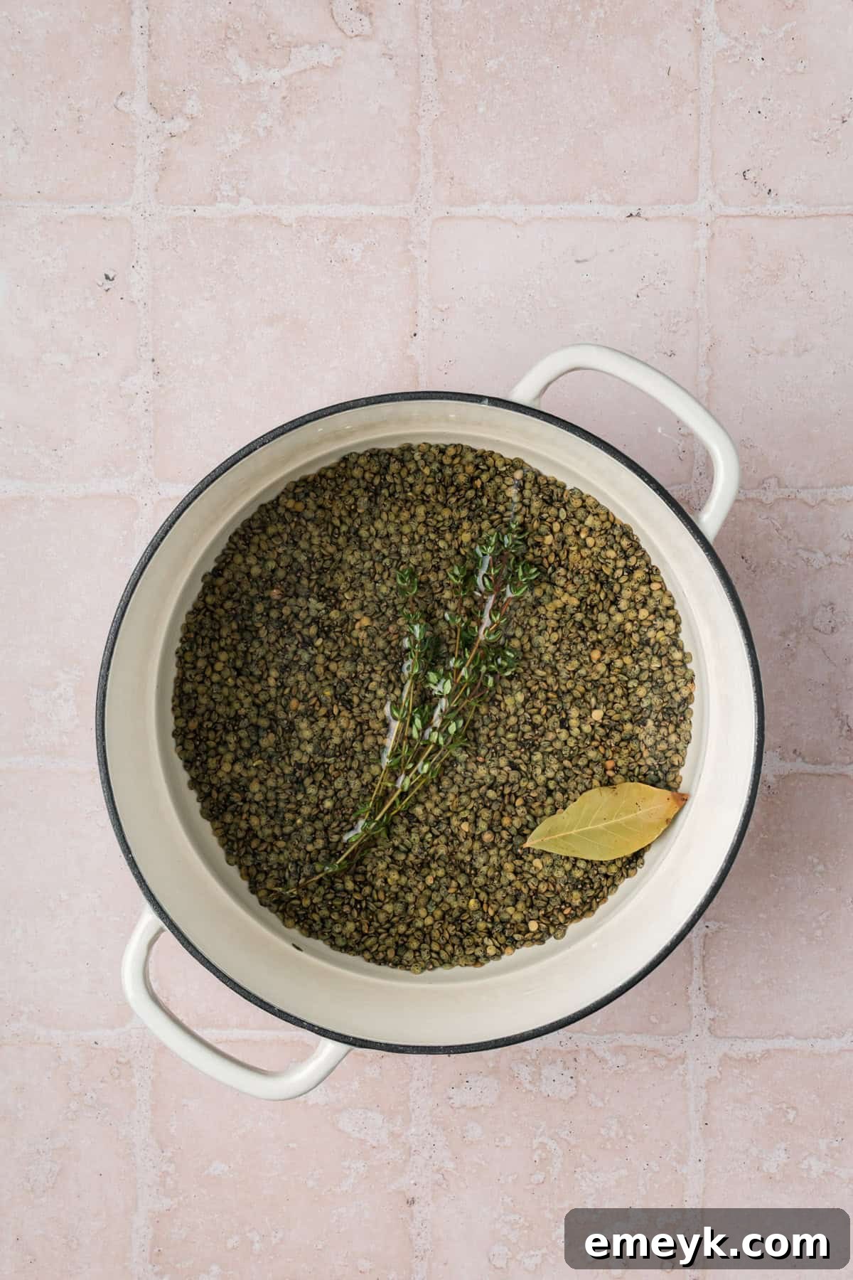 Hearty Green Lentil Salad with Olives, showing lentils cooking in a saucepan