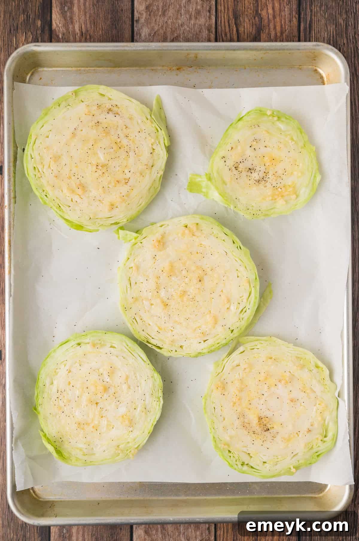 Cabbage Steaks arranged on a parchment-lined baking sheet