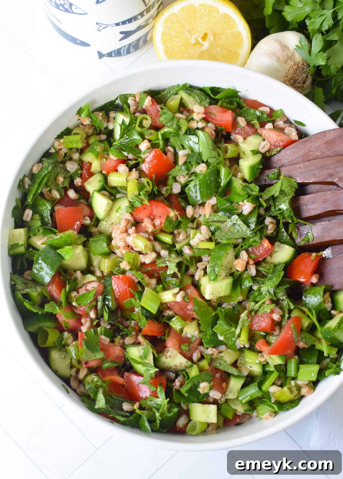 Mediterranean Farro Tabbouleh 2 Hearty Farro Tabbouleh Salad in a white bowl, garnished with fresh parsley and crumbled feta cheese