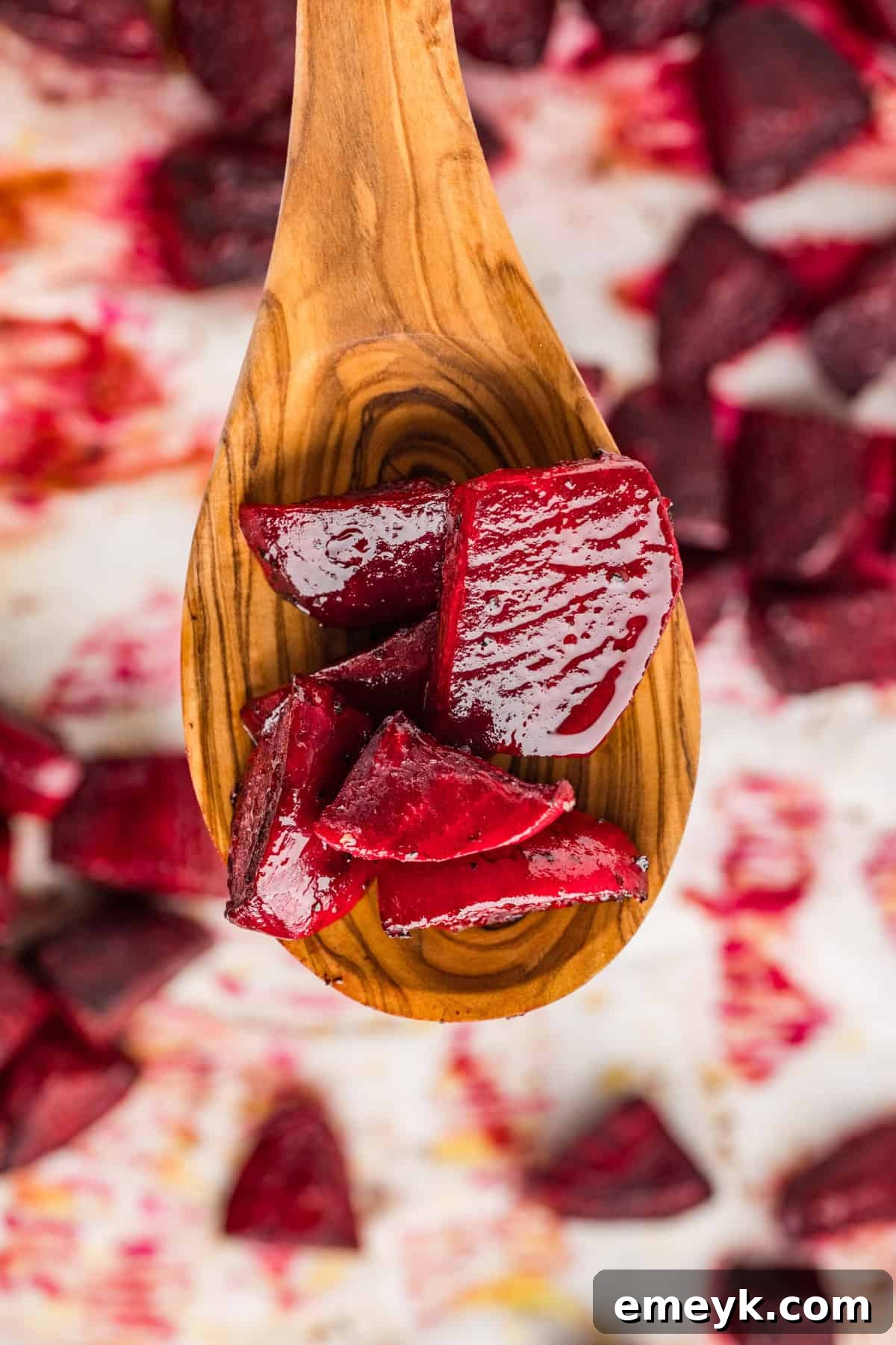 Quick and Easy Foil Free Roasted Beets 9 A close-up view of dark, caramelized roasted beets on a wooden spoon.