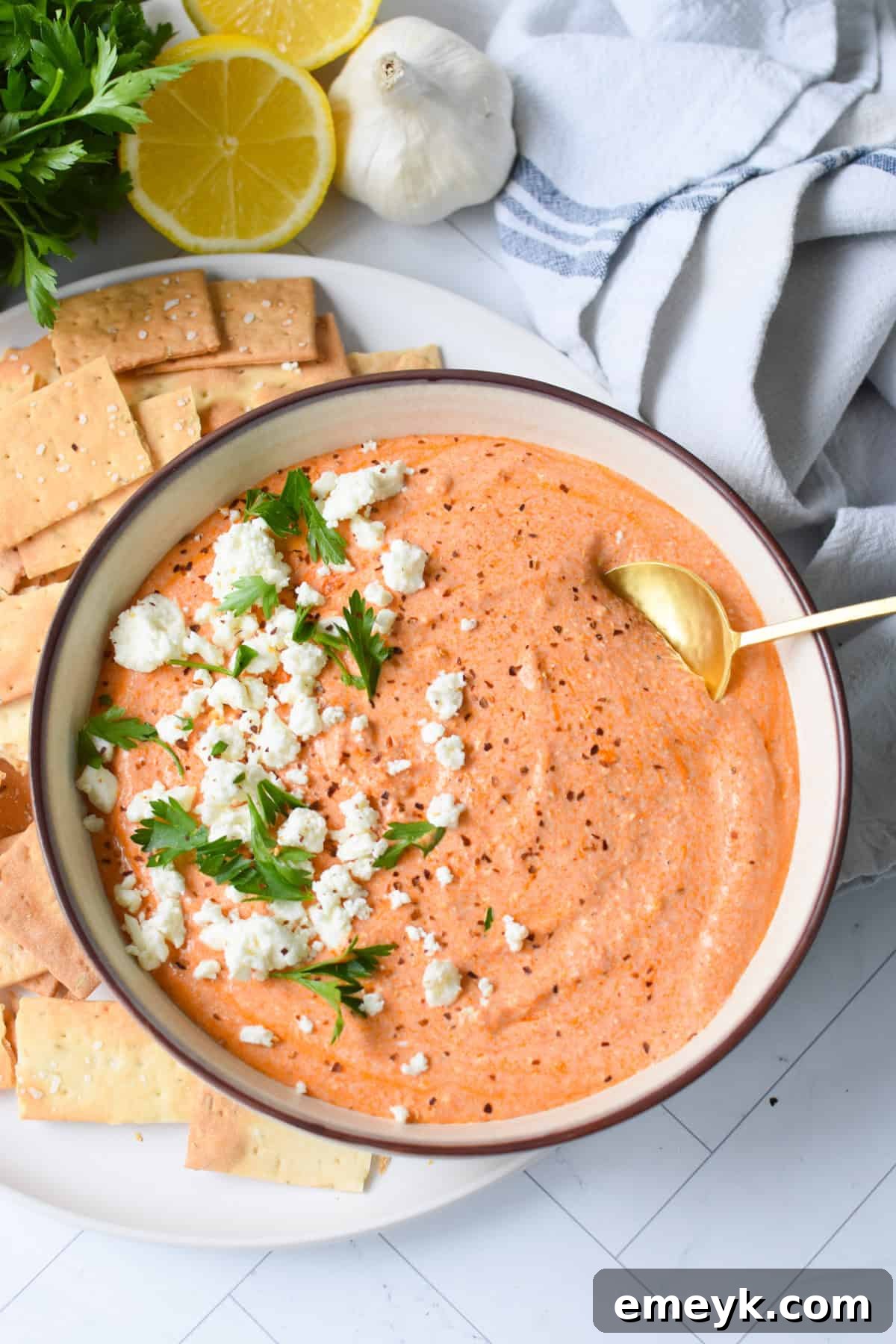 Spicy roasted red pepper feta dip in a serving dish, ready to be eaten.