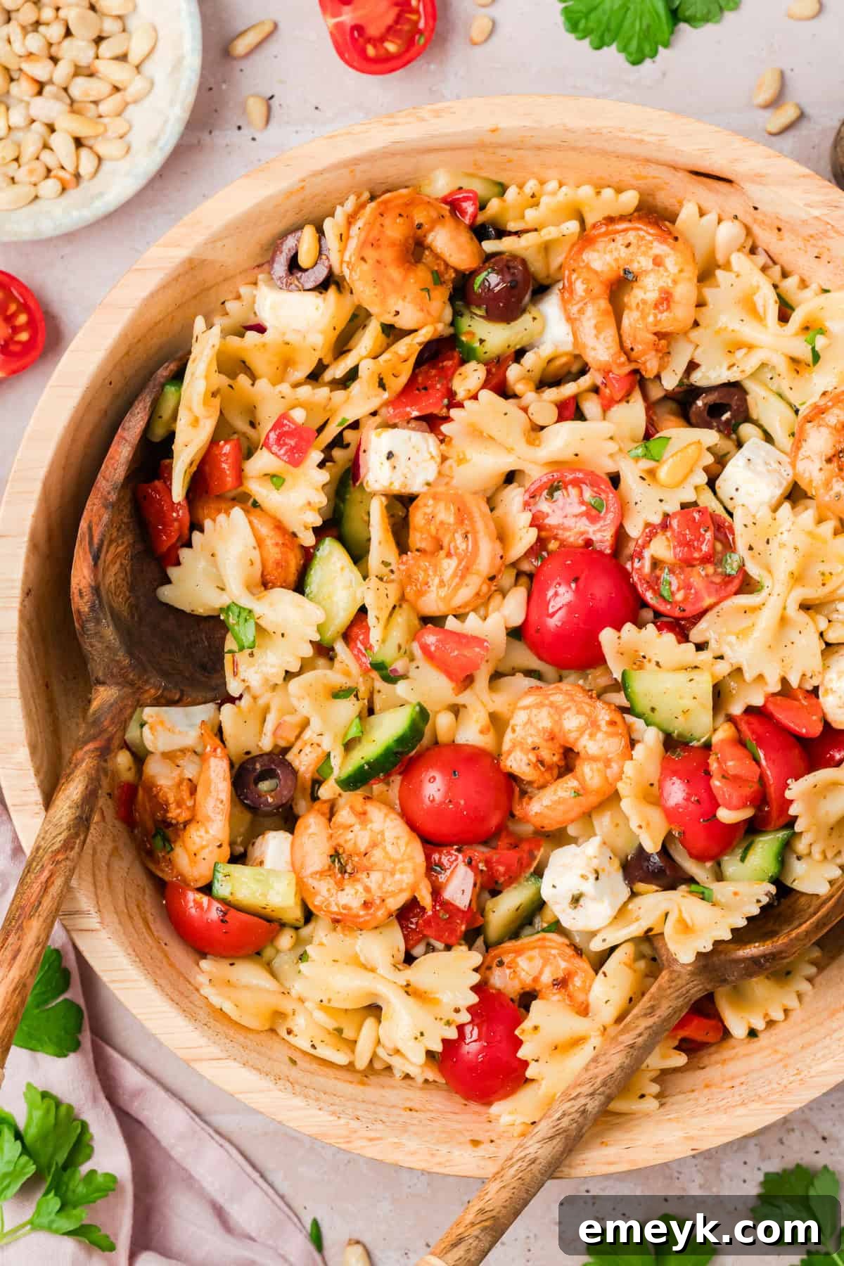 Farfalle pasta salad with seasoned shrimp, cherry tomatoes, cucumber, and feta cheese