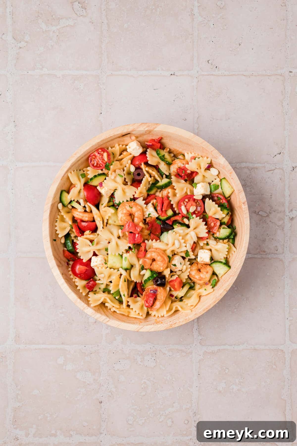 Close up of shrimp pasta salad with toasted pine nuts, Kalamata olives, and feta