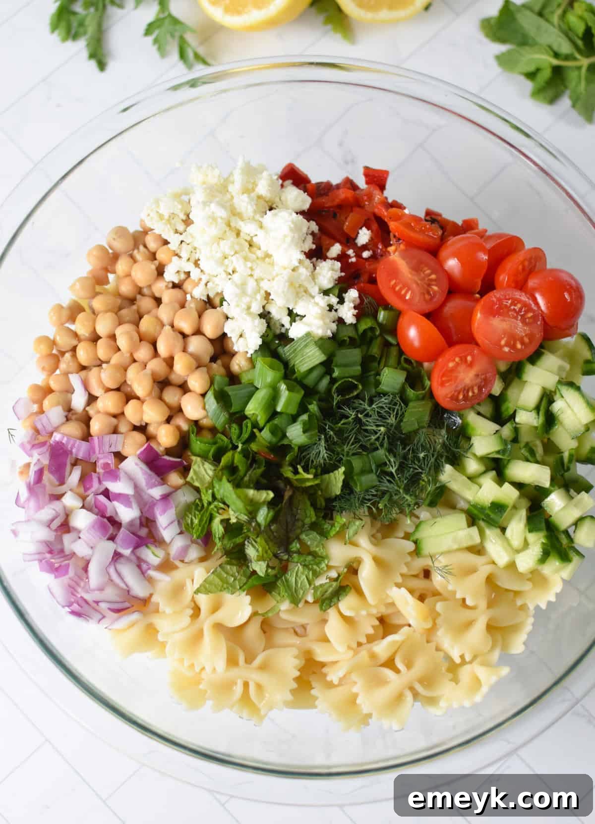 Bow Tie Pasta Salad ingredients in a glass bowl 