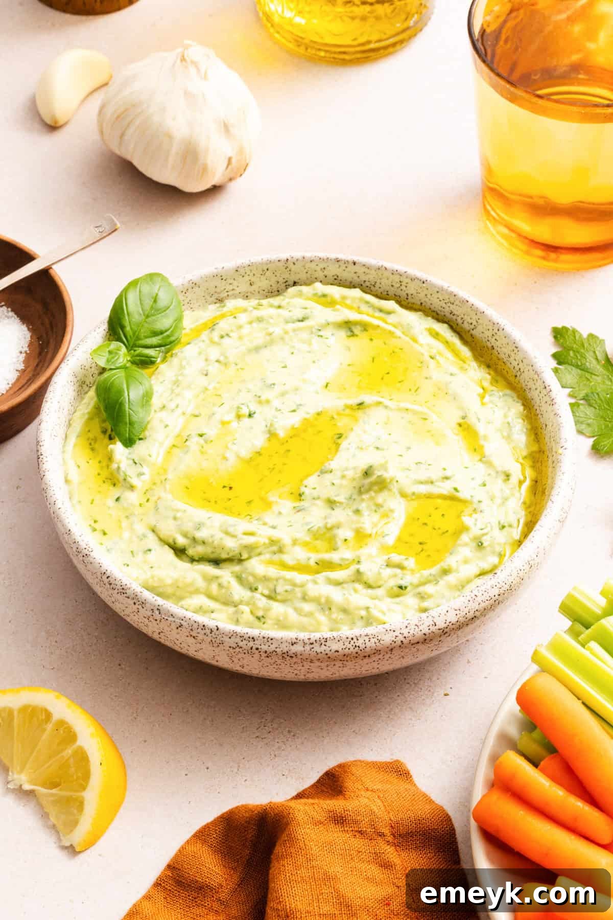 Green goddess dip with feta in a white bowl drizzled with olive oil 