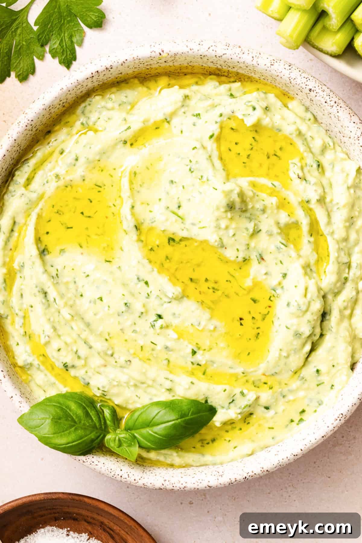 lose up of creamy green goddess dip with feta showing smooth vibrant green texture and olive oil drizzle