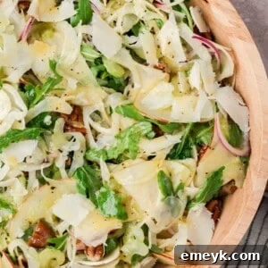 Apple fennel salad with pecans and shaved Parmesan in a tan bowl
