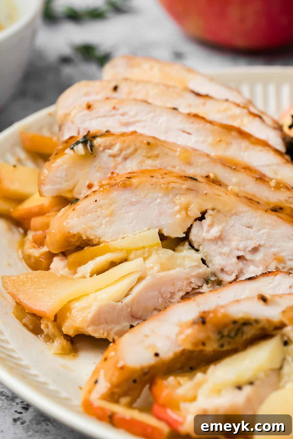 Sliced section of apple and brie stuffed chicken with maple Dijon glaze