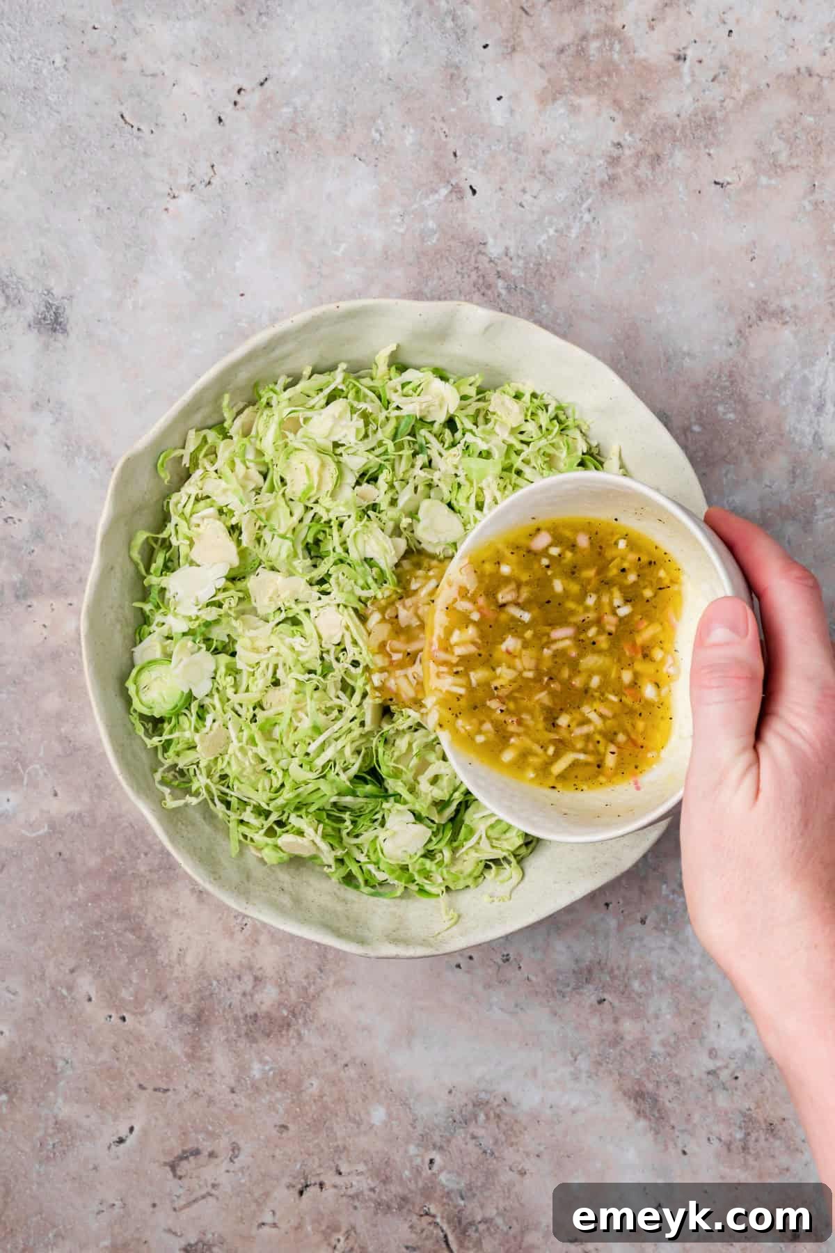 Dressing mixed with brussels sprouts in a bowl